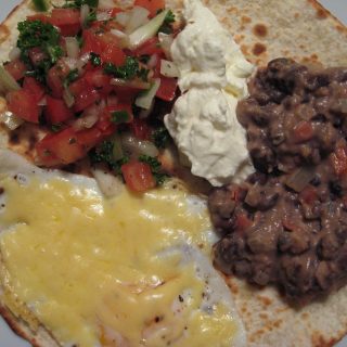 Huevos rancheros, feijões refritos, salsa, ovo e sour cream