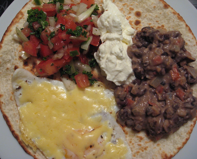 Huevos rancheros, feijões refritos, salsa, ovo e sour cream
